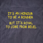 Bestickung in gelber Schrift auf schwarzem Stoff