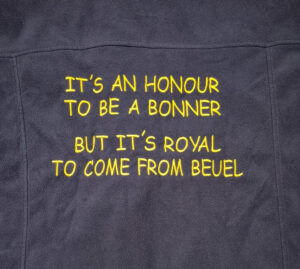 Bestickung in gelber Schrift auf schwarzem Stoff